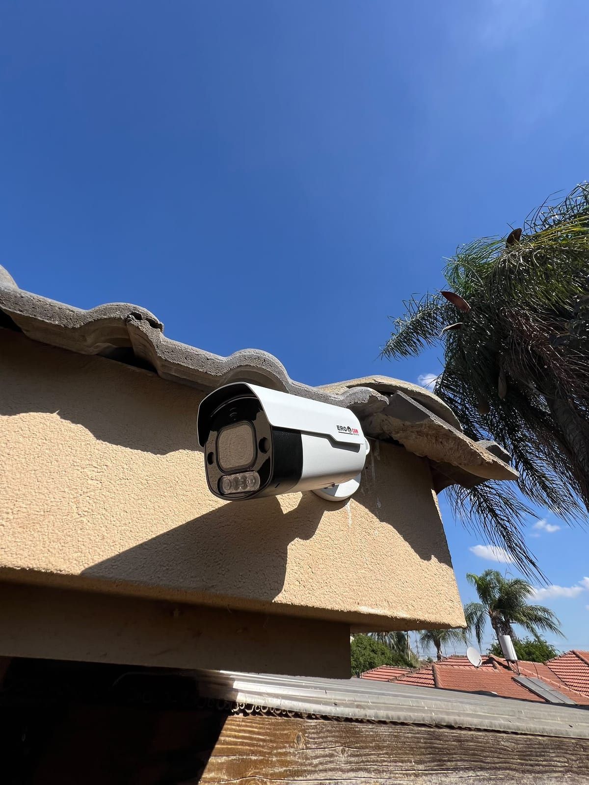 מצלמת אנליטיקה של EROCAM עם זיהוי פנים וזיהוי לוחיות רישוי, מותקנת מתחת לשולי גג רעפים